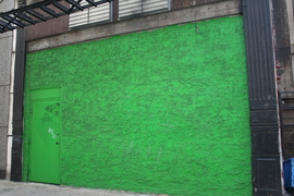 a green wall in an alley
